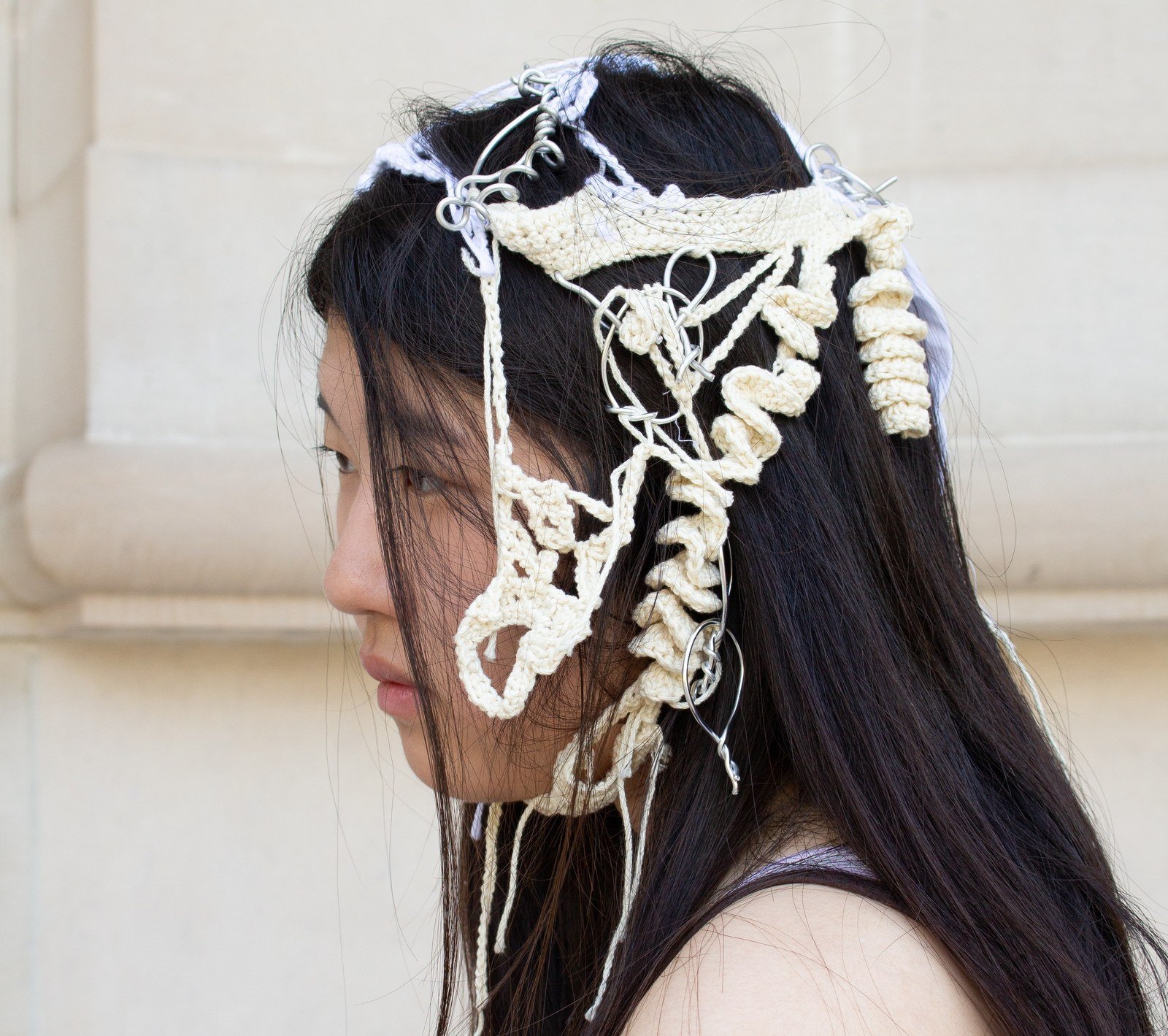 The crocheted headdress worn, wrapping around the face